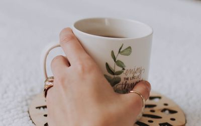 Close-up of a person's hands calmly holding a ceramic cup.